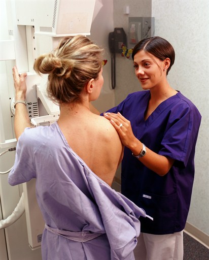 Technician helping woman during mammogram
