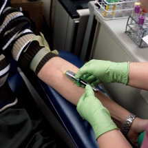 Lab technician drawing blood from a person's arm