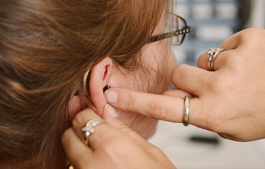 A patient is fitted with a new hearing aid at Speech Therapy & Audiology, Columbus Regional Health