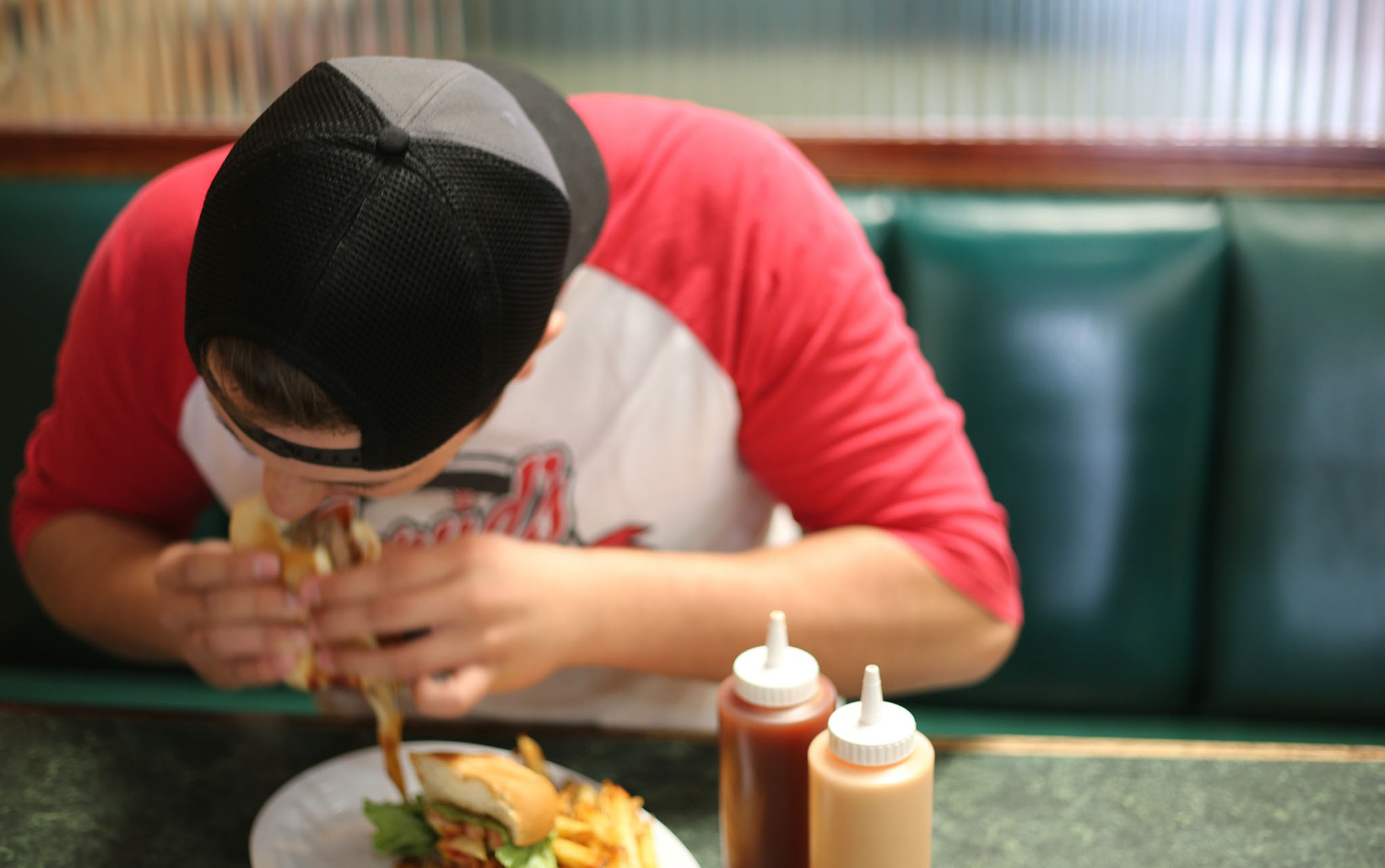 Man eating a hamburger in a fast food restaurant