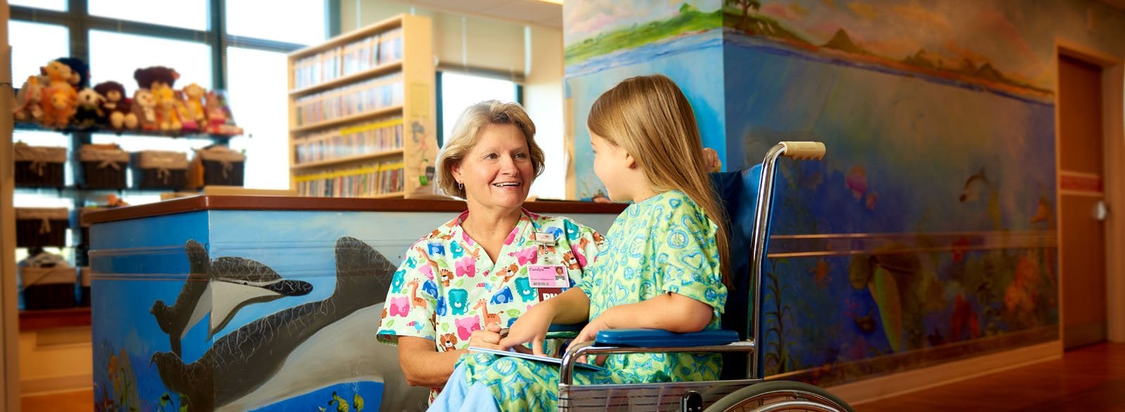 Nurse visiting with young girl in the pediatrics unit at Columbus Regional Hospital.