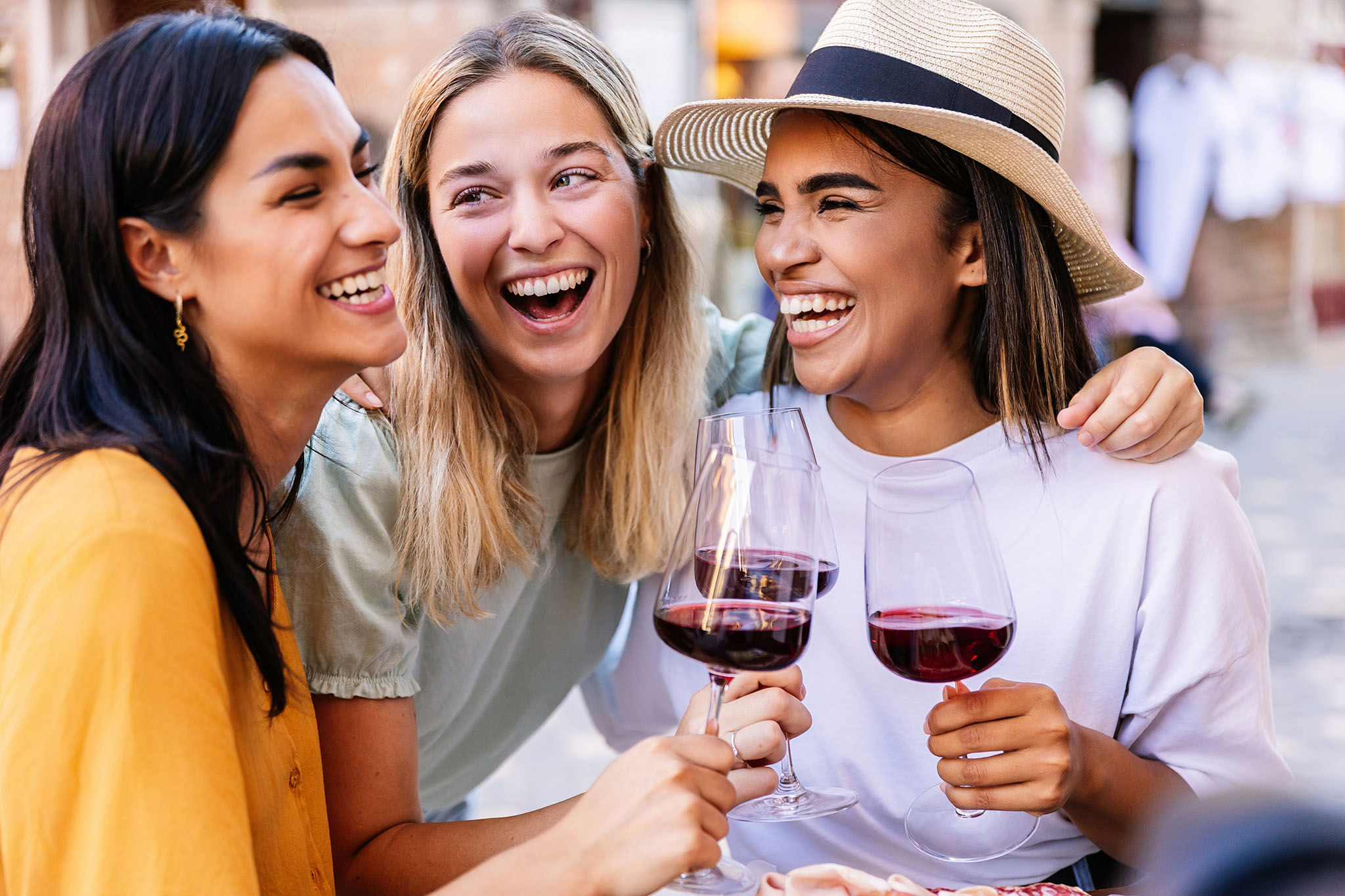 AdobeStock_926815591_blog Three women outside drinking red wine.