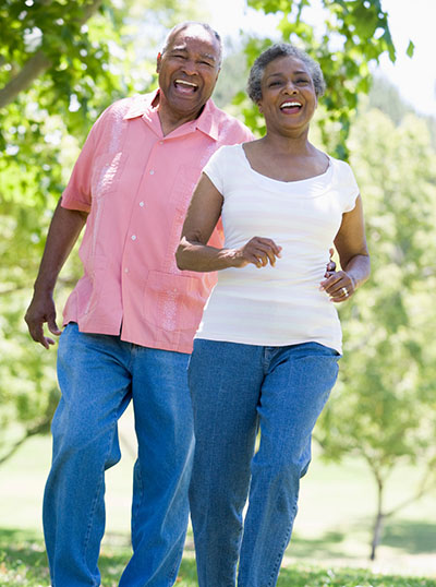 Middle-aged couple smiling and walking in nature.