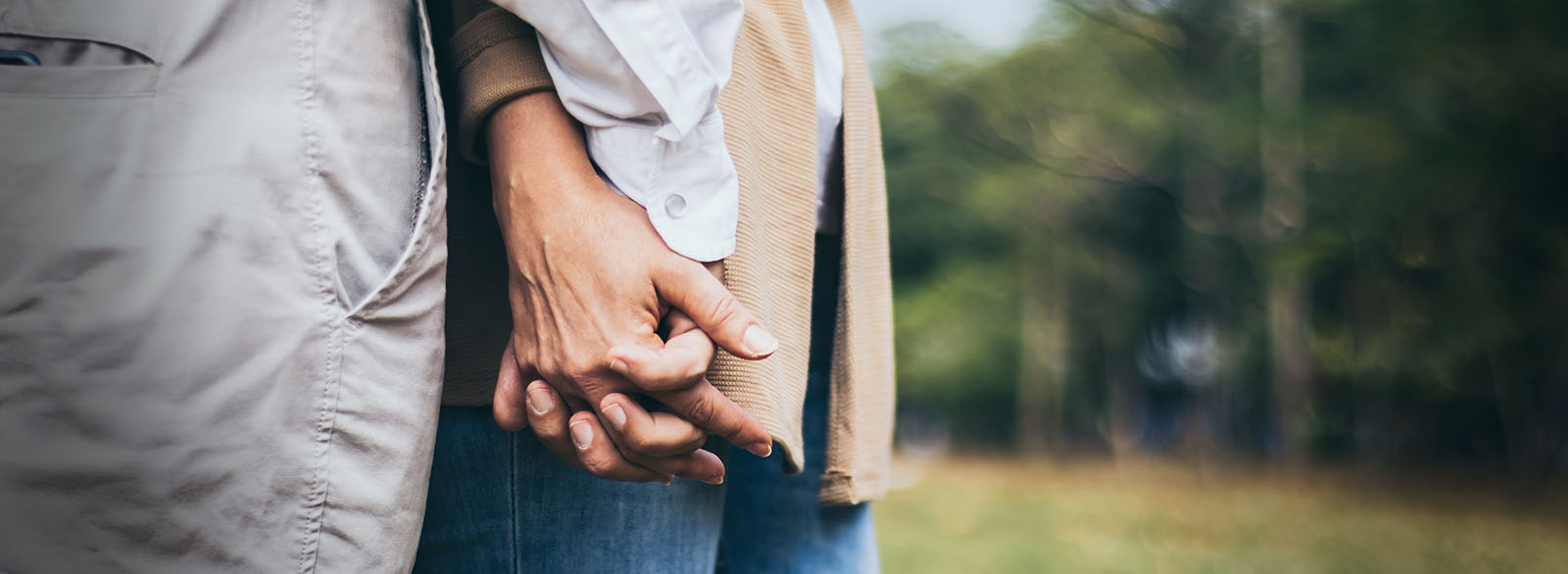 Closeup of older couple holding hands.