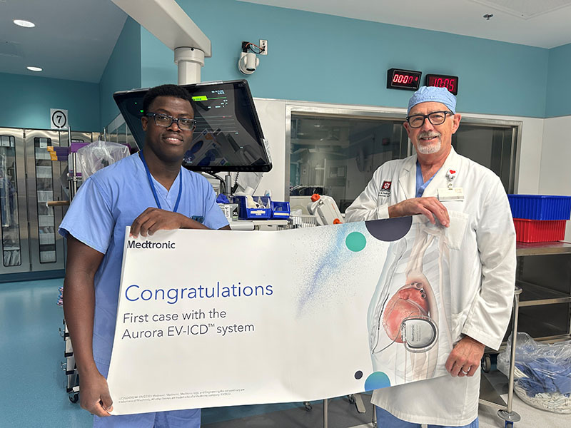 Dr. Albery Sey and Dr. Gregory Dedinsky holding banner.
