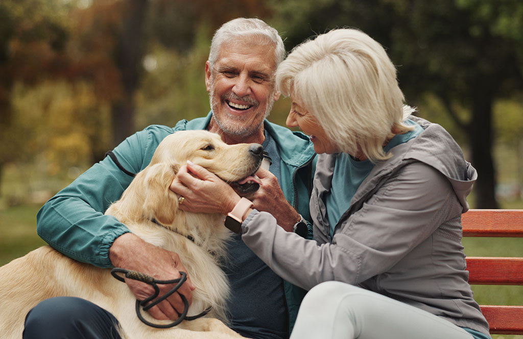 Couple and dog in park.