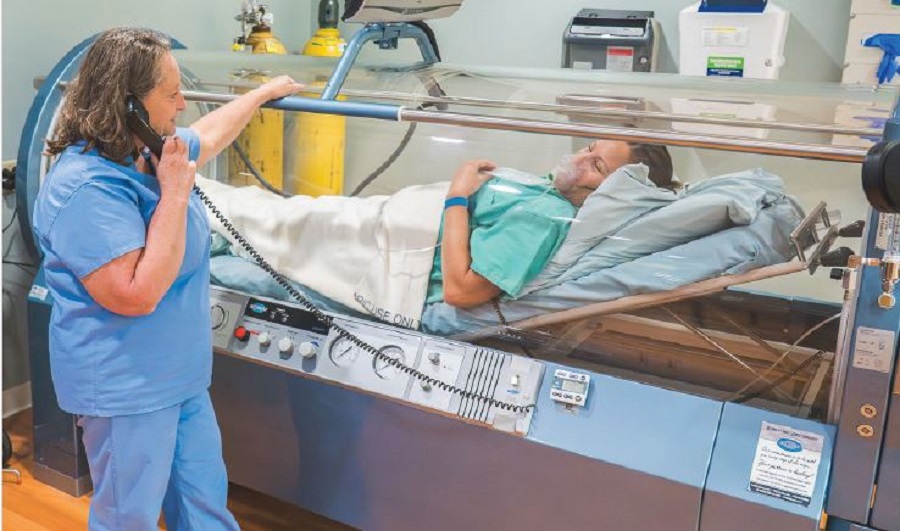 A nurse communicates with a patient inside the hyperbaric oxygen chamber at the Wound Center.