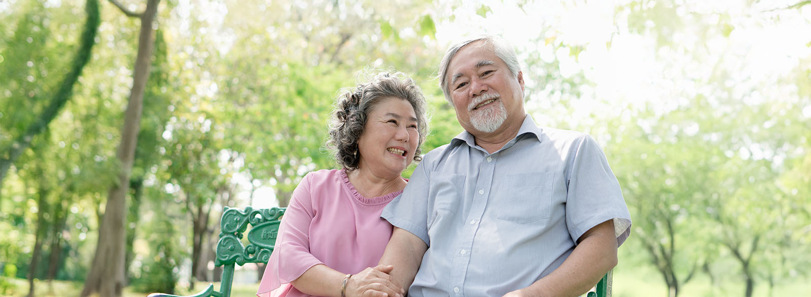 Healthy senior couple relaxing seated in the park together.