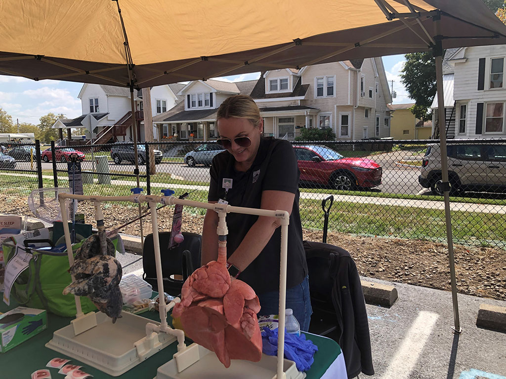 Staff member demonstrating pig lungs and tobacco cessation.