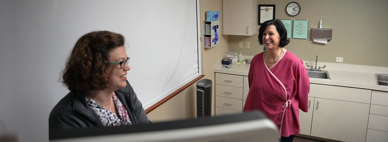 Cancer patient in exam room with a healthcare provider.