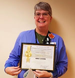 Andrea Valentine, Nurse Practitioner, holding certificate and gift bag.