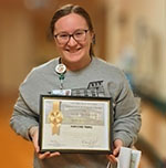 Madelynn Burns, Patient Care Technician, holding certificate and gift bag.