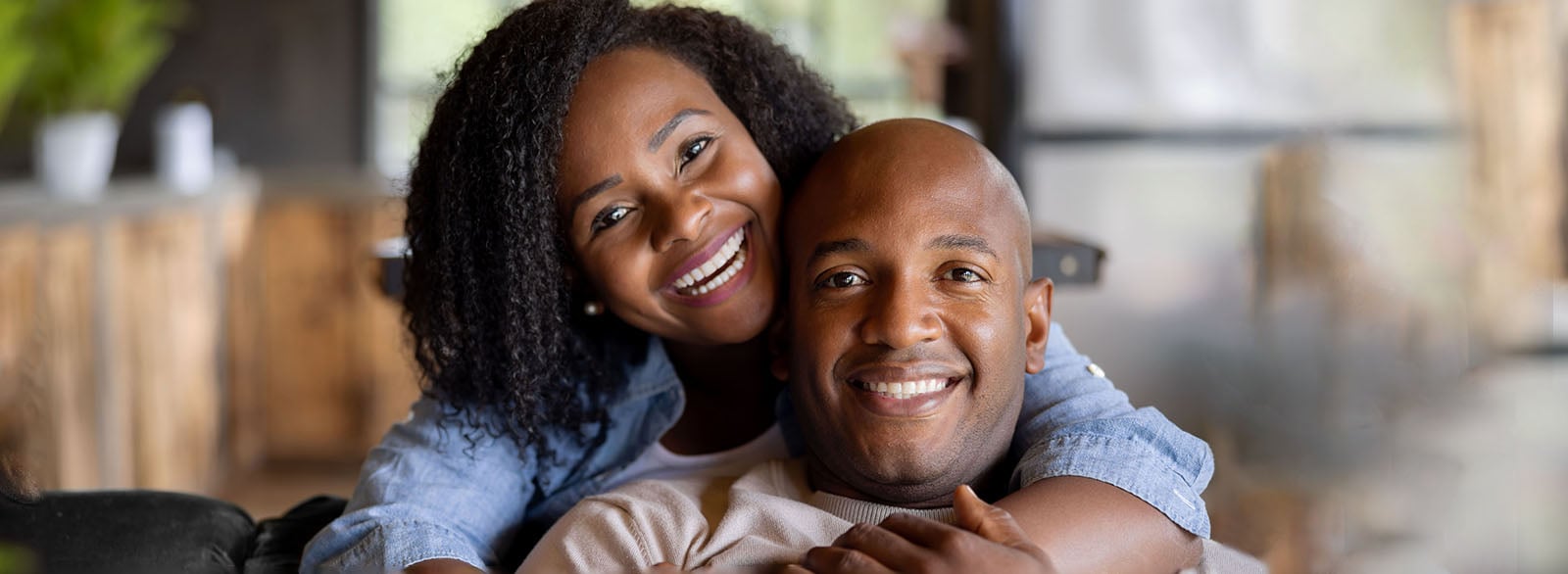 Portrait of a loving African American couple smiling at home and looking at the camera.