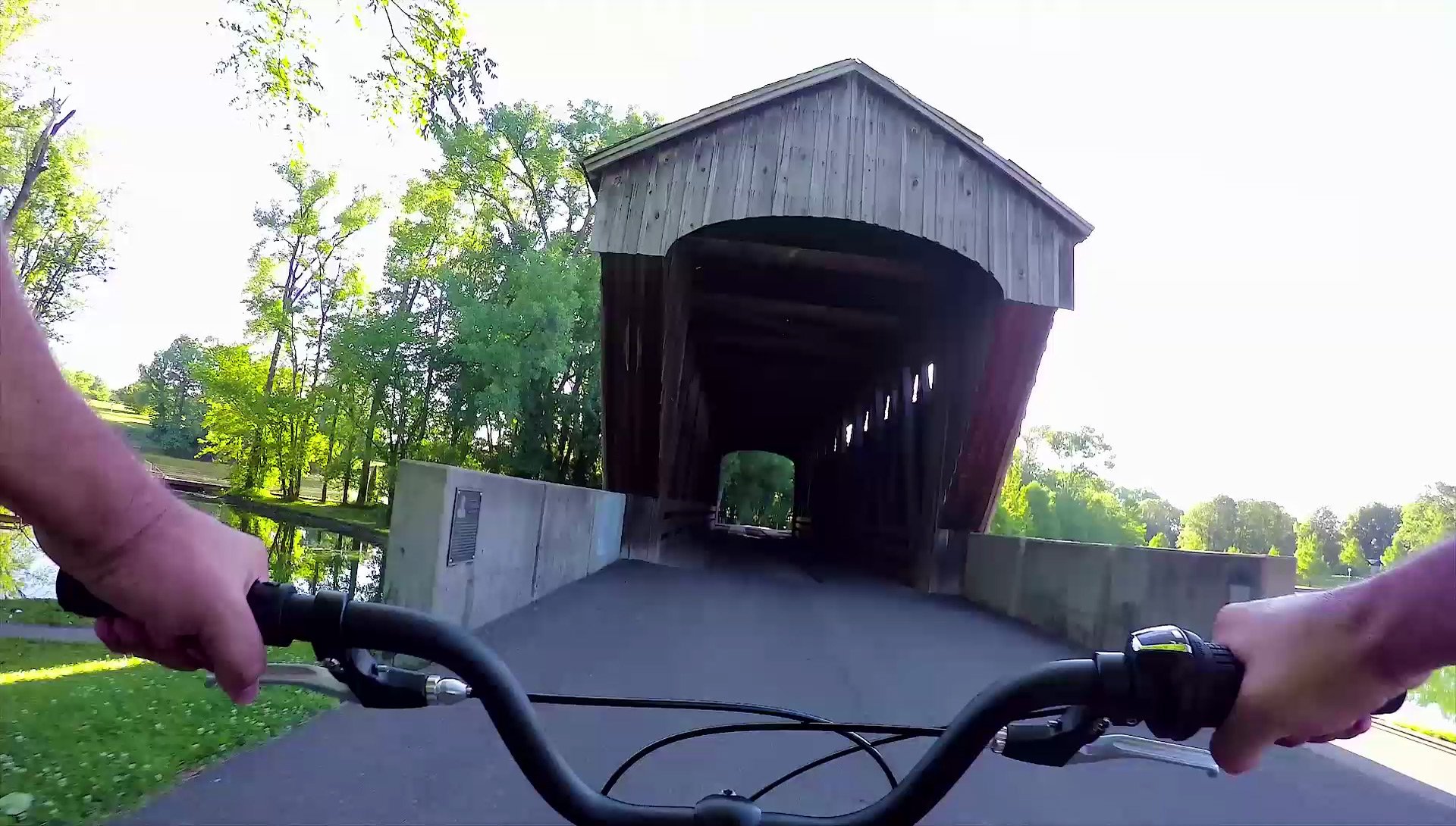 POV angle of active person riding a bicycle toward a covered bridge in Columbus, Indiana.
