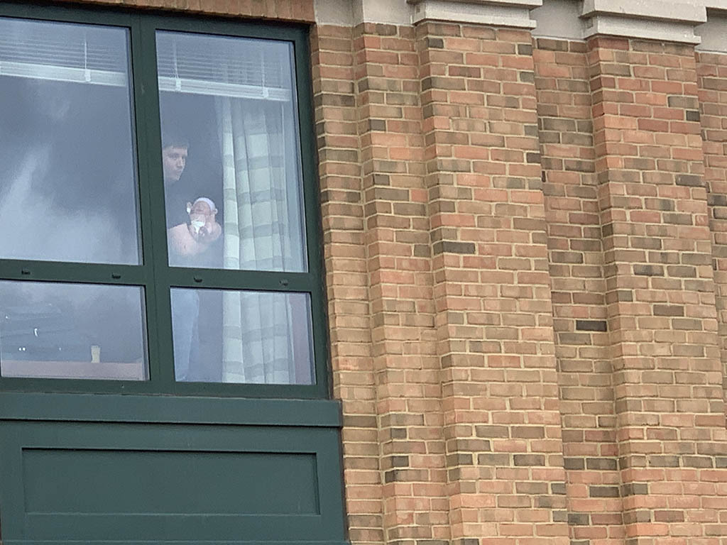 A father holds his newborn baby in the window of the Birthing Center at Columbus Regional Health.